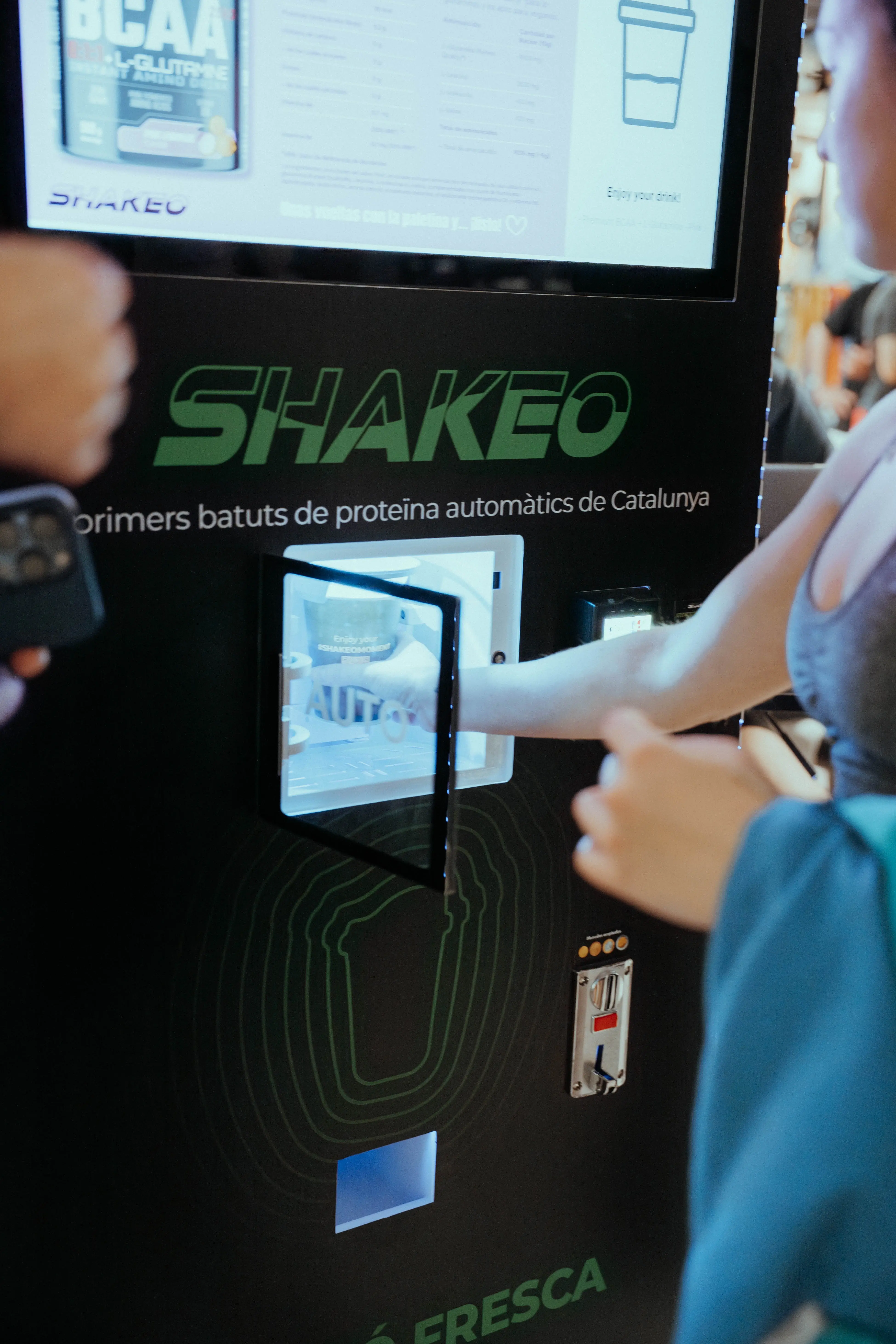 Customer using SHAKEO vending machine touchscreen